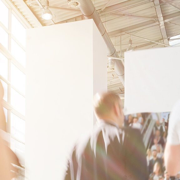 People walking around an exhibition hall at an event